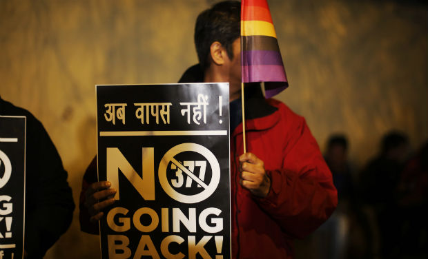A gay rights activist holds up a placard and a flag during a protest in New Delhi on Tuesday - AP A gay rights activist holds up a placard and a flag during a protest in New Delhi on Tuesday - AP
